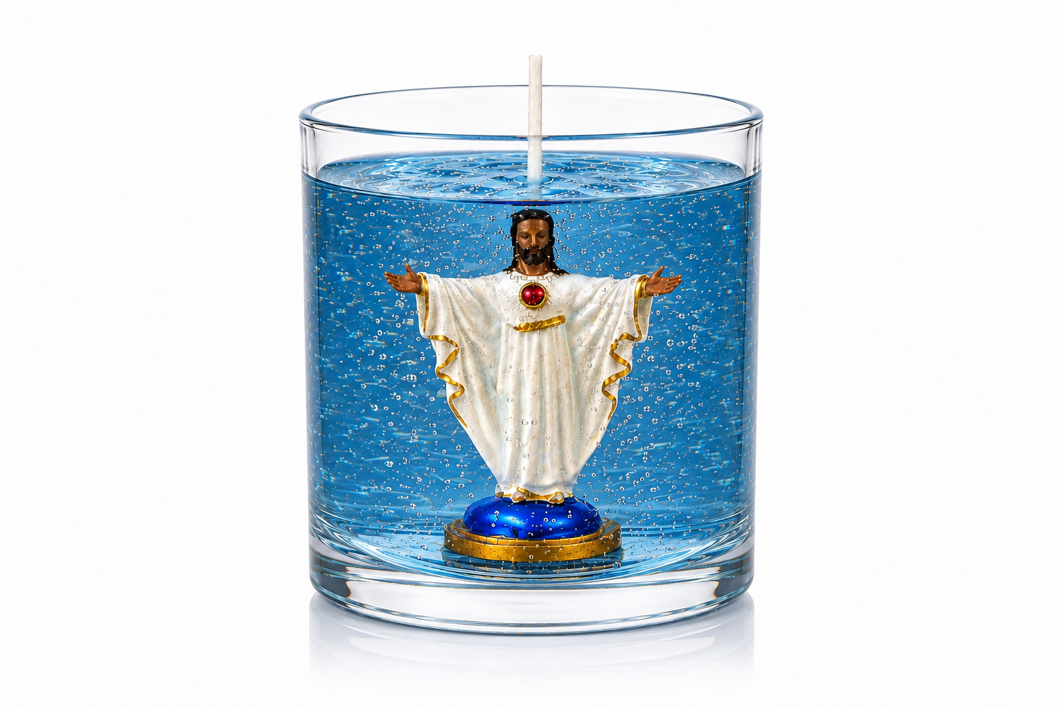 Vela em gel azul transparente com microbolhas decorativas em recipiente cilíndrico de vidro. No interior encontra-se uma imagem do Sagrado Coração de Jesus com vestes brancas, detalhes dourados, coração vermelho destacado no peito e braços abertos em gesto de acolhimento. A peça está fotografada sobre fundo branco, evidenciando os detalhes artesanais, a transparência do gel e a temática religiosa da vela.
