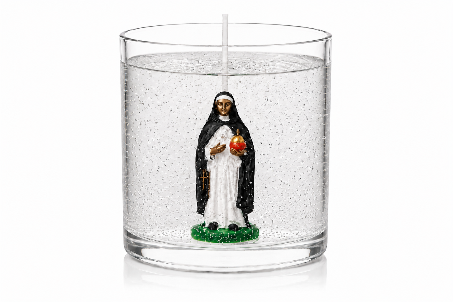 Vela em gel transparente com microbolhas decorativas, acondicionada em recipiente cilíndrico de vidro transparente. No centro da peça encontra-se uma miniatura de Santa Edwiges vestida com hábito preto e branco, segurando um globo dourado e vermelho e uma pequena cruz dourada. A vela possui pavio centralizado e está fotografada sobre fundo branco, em estilo de catálogo de produto, destacando os detalhes artesanais e a transparência do gel.