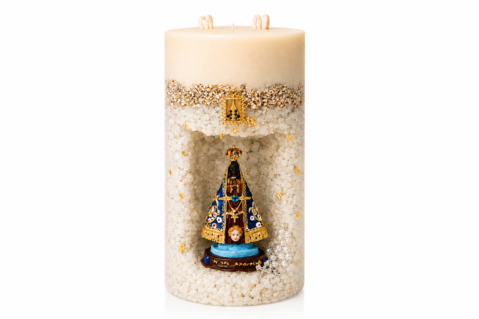Vela Gruta de Nossa Senhora Aparecida artesanal em formato cilíndrico, com acabamento em tons marfim e textura composta por pequenos cristais decorativos. A peça possui um nicho central com a imagem de Nossa Senhora Aparecida em azul, dourado e preto, acompanhada por delicados detalhes dourados e um pequeno terço decorativo. A vela está apresentada sobre fundo branco em estilo catálogo profissional.